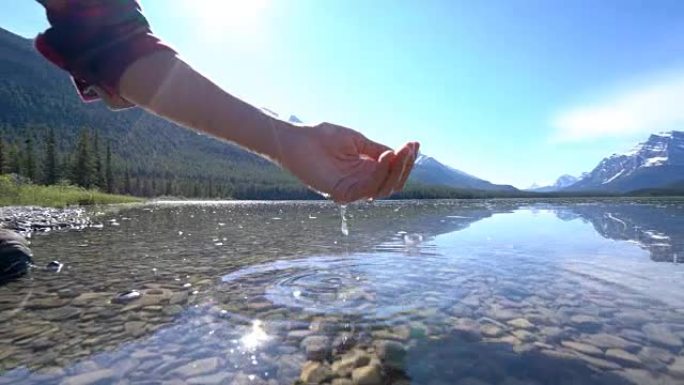 人的手被杯托以从山湖中捕获淡水