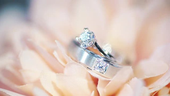 粉色花朵结婚戒指的宏观照片。婚礼主题。