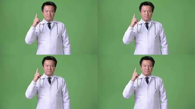 绿色背景下的成熟日本男人医生