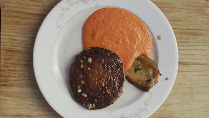 A chef is pouring a pepper purèe in a nice plate