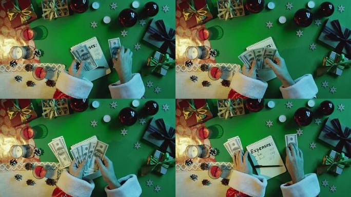 圣诞老人在笔记本上数钱，费用用新年表用色度键，自上而下拍摄