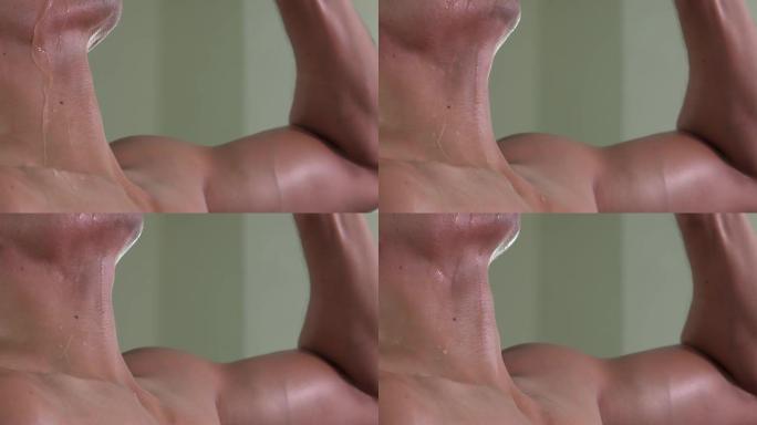 肌肉发达的男人喝水的脖子特写