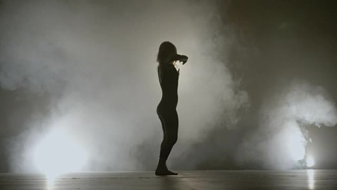 年轻的健康女孩在烟雾背景下跳舞，同时为一位著名歌手录制音乐视频剪辑