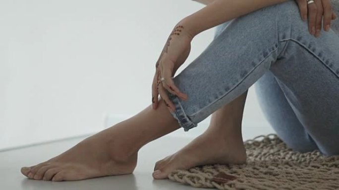 一名青少年身体的特写镜头，一名女士的手上有一个用指甲花制成的纹身