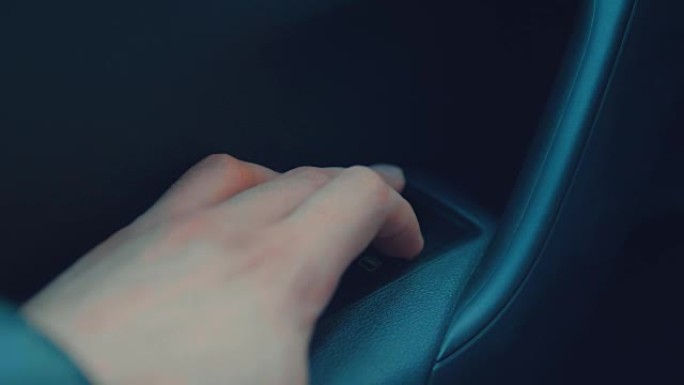 手指按下按钮控制车内的车窗。