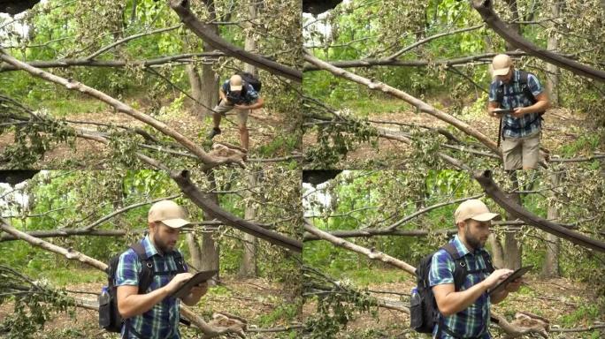 年轻，迷路的人带着平板电脑在森林上寻找方向。慢动作。
