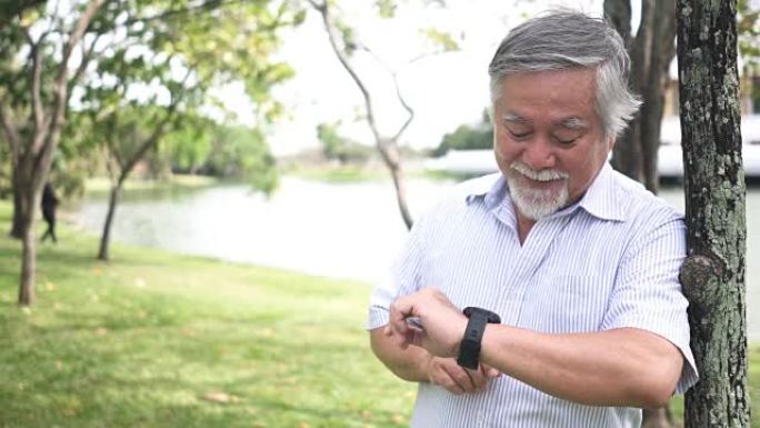 前视图: 亚洲资深人士正在检查智能手表