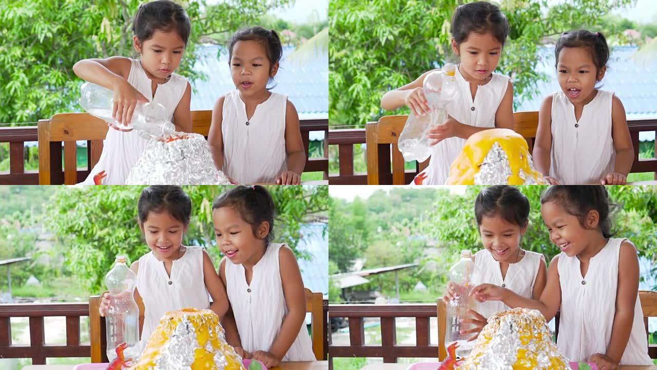 两个亚洲小女孩在家里的桌子上做小苏打和醋火山实验，以50 fps的速度慢动作