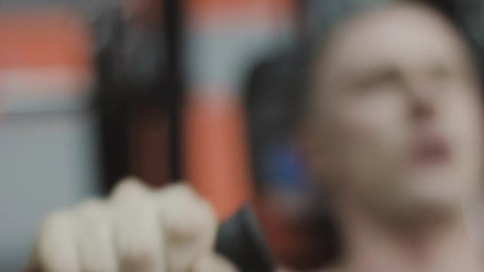 一个身体裸露的肌肉发达的男人在健身俱乐部的健身机上训练