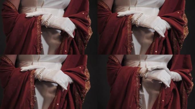奢华的复古女人与昂贵的珠宝在白色和红色的历史18世纪礼服摆姿势。戴着长丝绸手套的女孩。慢动作