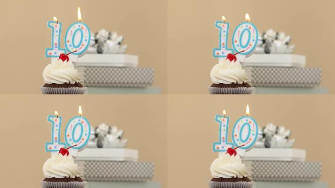 纸杯蛋糕粉彩背景中的十支蜡烛