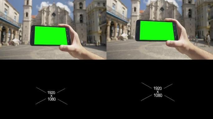 在哈瓦那大教堂附近持有绿屏智能手机