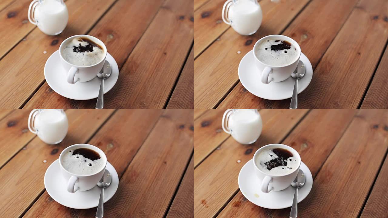 用手将糖滴入木桌上的咖啡杯中