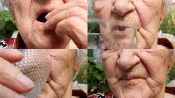 老妇人吃药喝杯水。祖母把药片放进嘴里。医疗保健和医疗概念。关闭慢动作