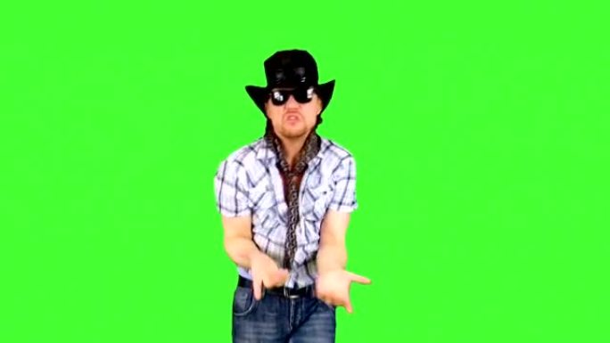 戴着帽子和太阳镜的开朗酷牛仔正在开玩笑地跳舞，唱歌和享受