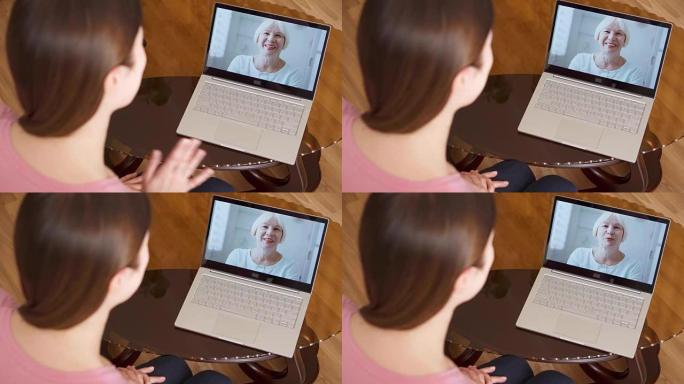 出国留学的女儿通过messenger应用程序与她的资深母亲在笔记本电脑上进行视频聊天