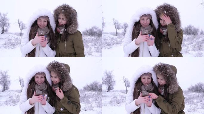 冬季，有吸引力的女孩在降雪期间坐在社交网络中使用小工具