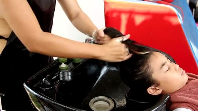 亚洲女孩用头部水疗中心洗头