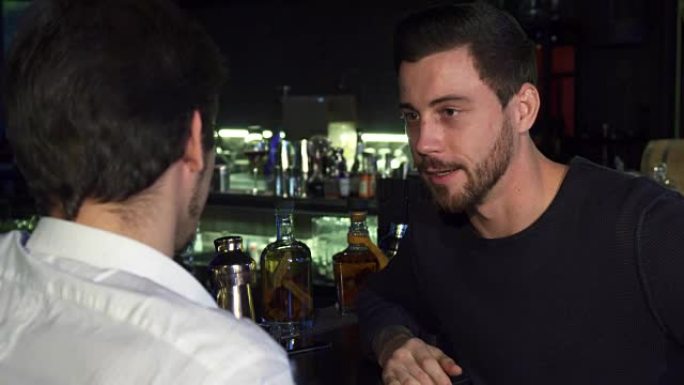 年轻的男性朋友在酒吧一起喝酒时聊天