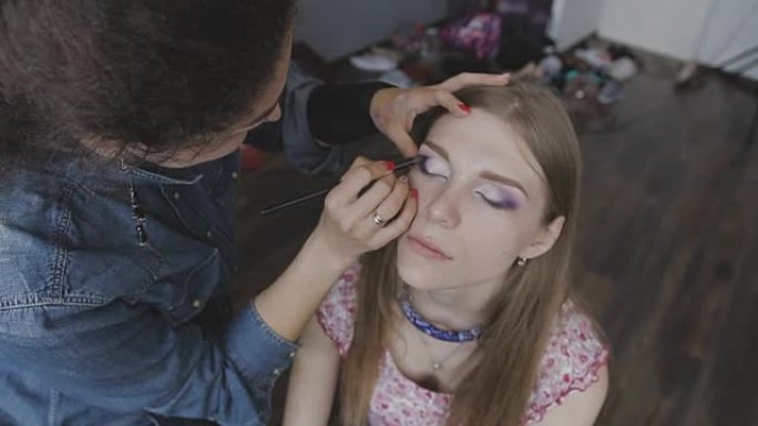 化妆师在照相馆为一个非常漂亮的女孩做专业化妆
