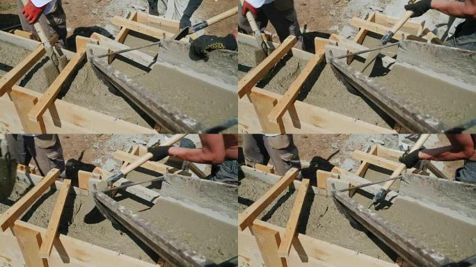 在建造小房子时与混凝土一起工作。液体混凝土倒入木制模板，使建筑物的基础