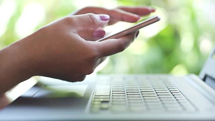 女人手使用智能手机进行网上银行，取款和转账与电脑笔记本电脑背景