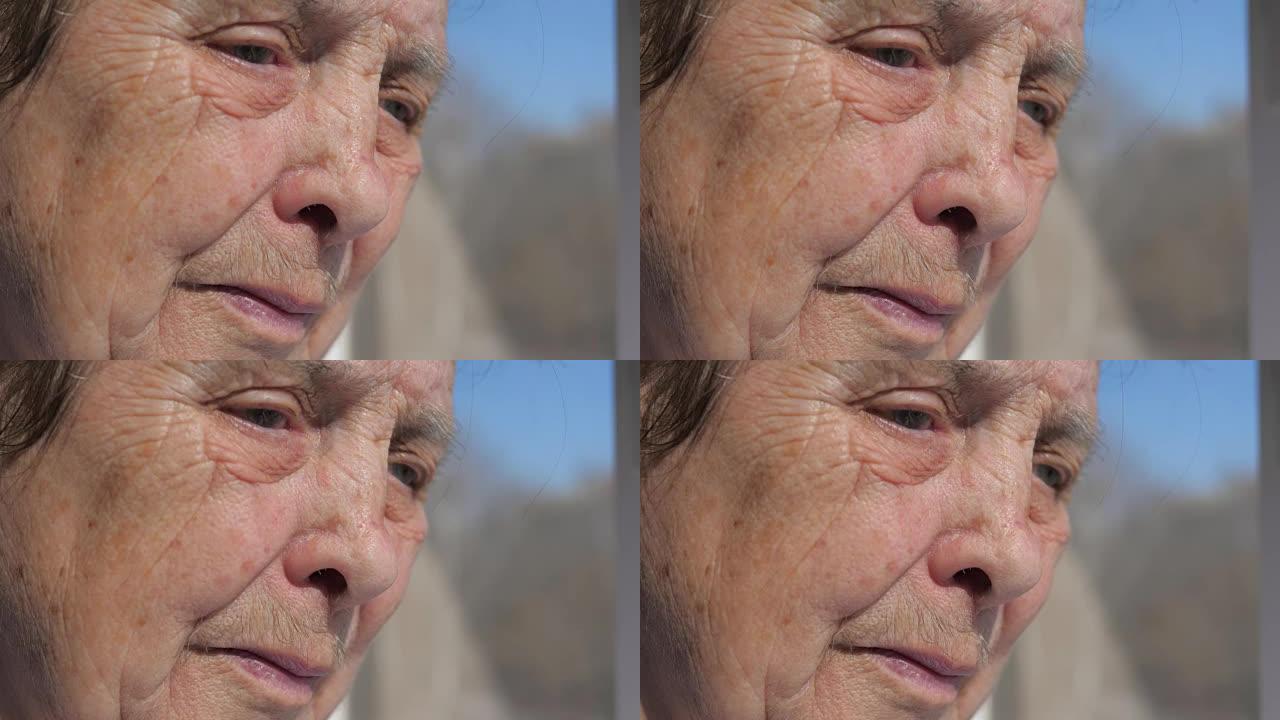 一位患有颤抖的眼睑的老妇人的悲伤面孔的特写