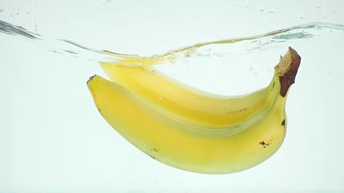 香蕉在慢动作的白色背景下陷入水中