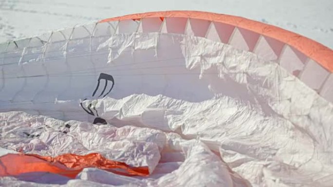 滑翔伞比赛。降落伞躺在雪地上