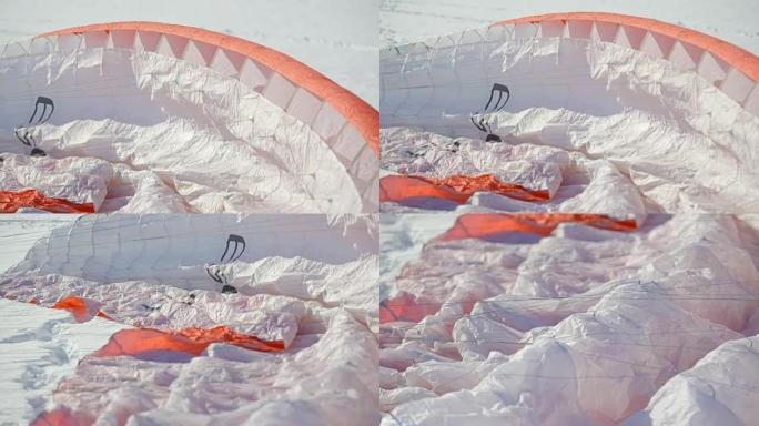 滑翔伞比赛。降落伞躺在雪地上