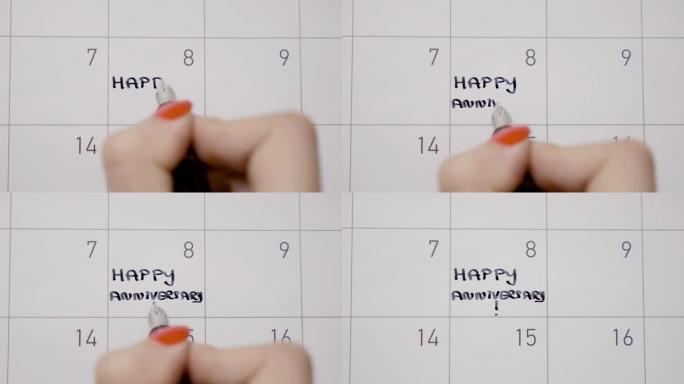 女人的手通过用黑笔写周年快乐来纪念日历上的日子