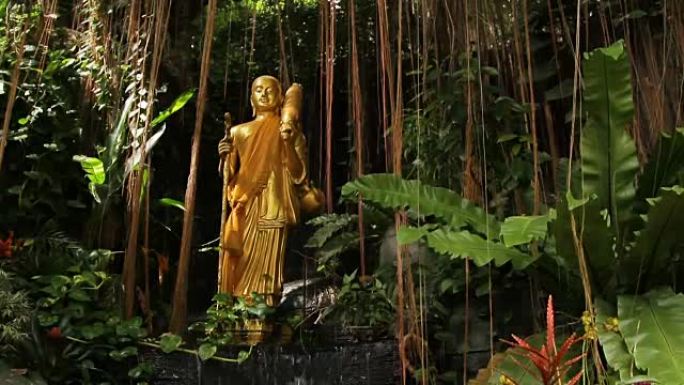 灌木丛中的金色雕塑。泰国曼谷金山Wat Saket