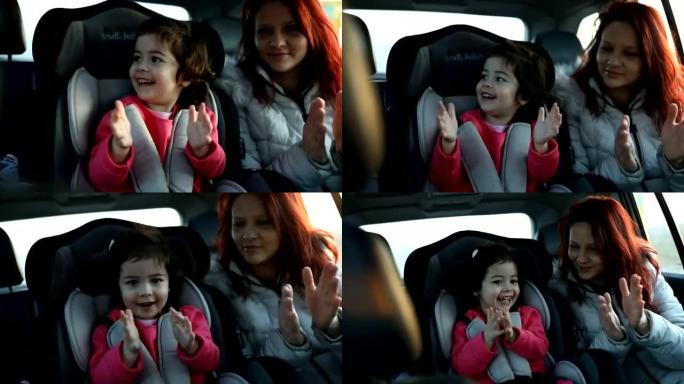 母亲和小女儿坐在汽车后座上