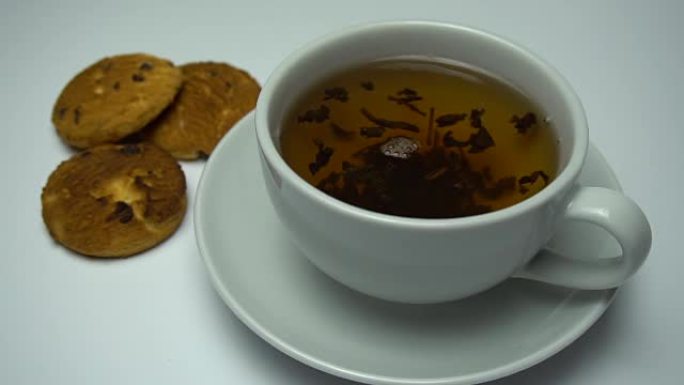 茶被旋转成杯子和饼干的特写镜头。放大