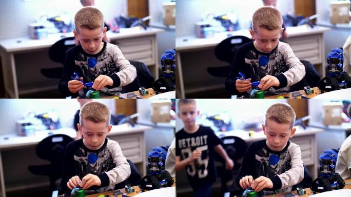 10岁的男孩，从立方体，盘子，电路，电线在设计师中扮演角色。一个小发明家从设计师的不同部分创建机器人