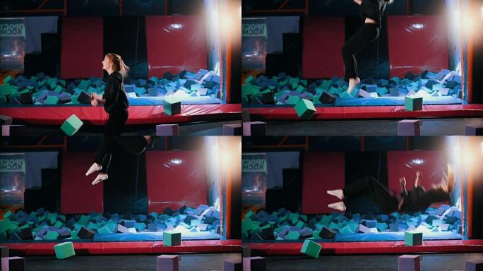 年轻的运动女杂技演员表演杂技技巧-在蹦床大厅跳跃，慢动作
