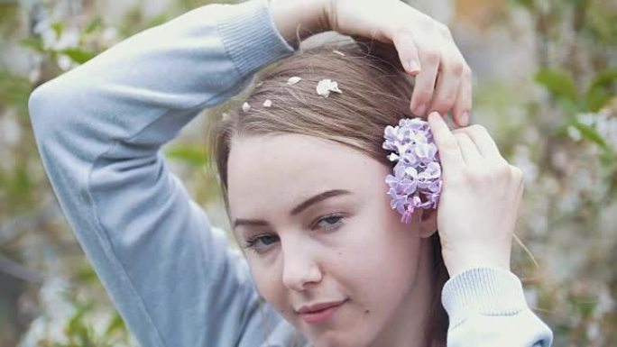 花园女孩的年轻女子肖像在头发上插了一枝丁香