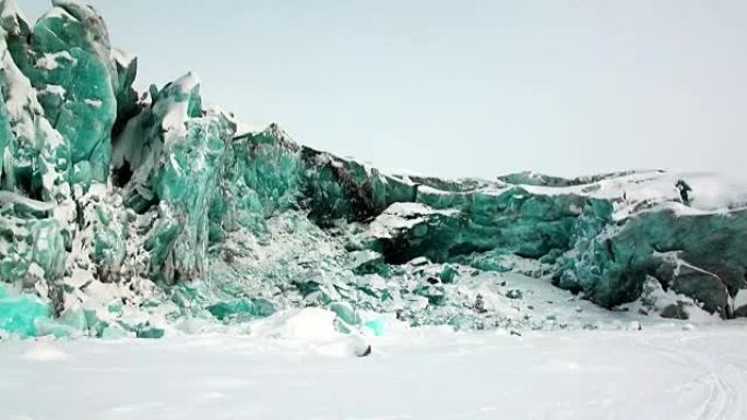 北极积雪背景下的绿松石色冰川。