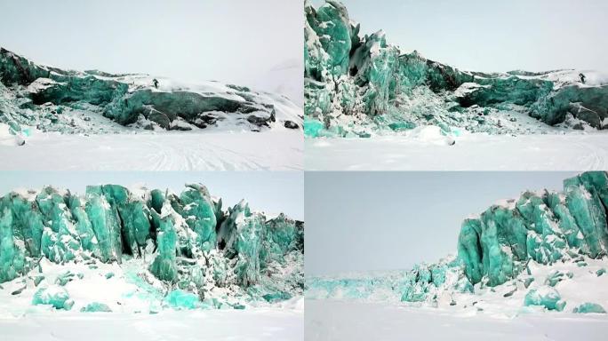北极积雪背景下的绿松石色冰川。