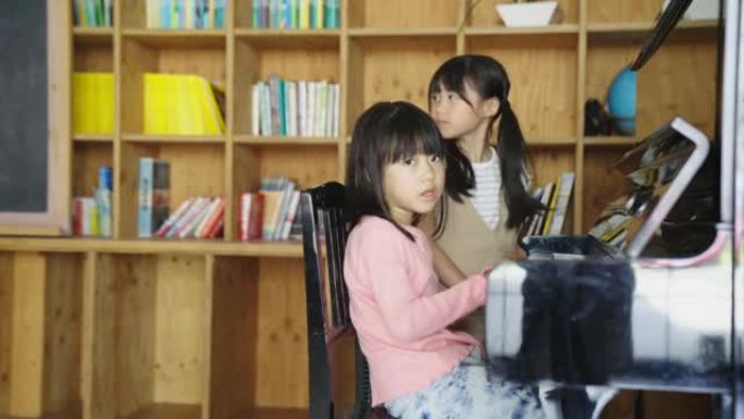 年轻女孩一起弹钢琴