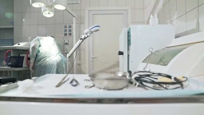 外科医生在医院工作，并在手术前准备医疗器械。戴眼镜、职业装、无菌口罩和睡袍的医生。健康的概念，在诊所