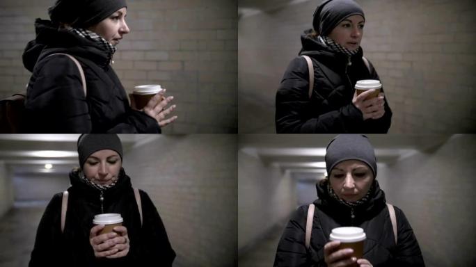 漂亮女人走过隧道，喝咖啡，冬天