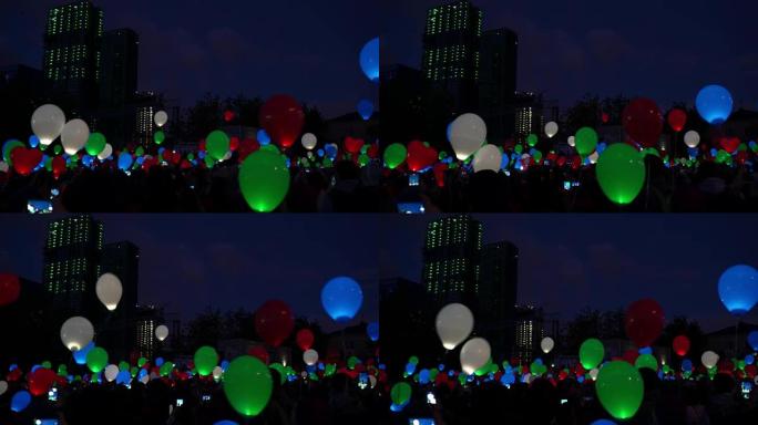 爱情盛宴的概念。夜城天空中的彩色氦气发光气球气球