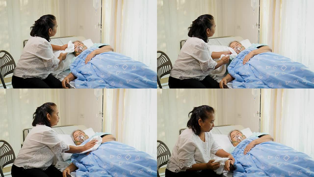 亚洲女儿温热的海绵，牵着母亲躺在病房的床上