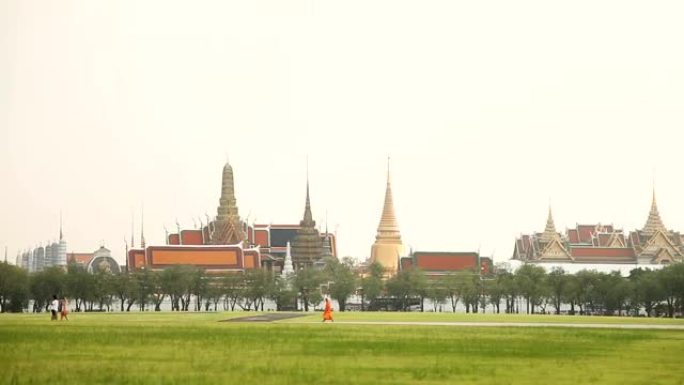 人们穿过田野经过皇宫。泰国曼谷