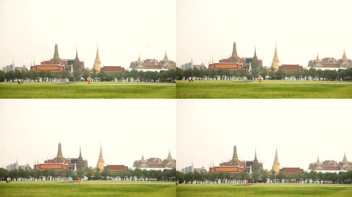 人们穿过田野经过皇宫。泰国曼谷