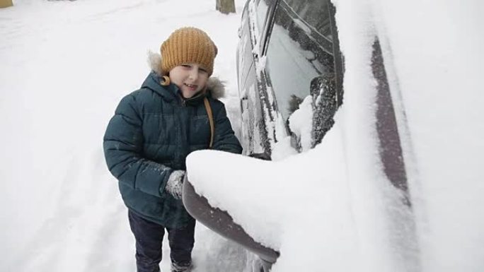 冬天早上，小男孩在户外清洁一辆雪车。