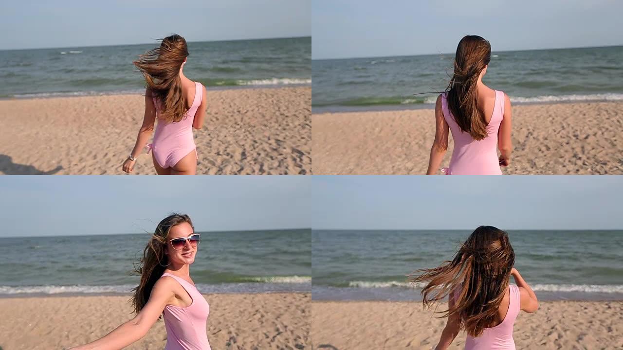 女人在海滩上漫步到海水，转身并邀请她去度假旅行。穿着粉色泳衣的热带白色沙滩上身材苗条火辣的女士走向海