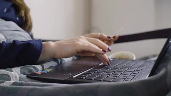 年轻女子在笔记本电脑上从互联网上购买商品的特写镜头