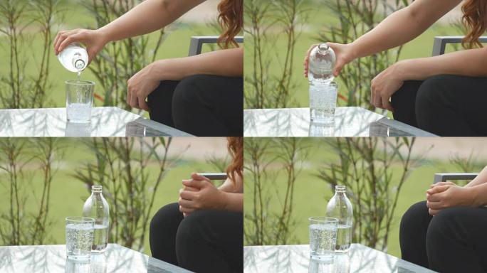 4k的女人用手在桌子上的水晶玻璃上水